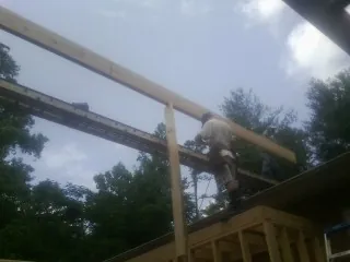 Carpenter setting a ridge beam over a new addition frame — Ice Dam Removal by Roofing Brothers in West Jefferson