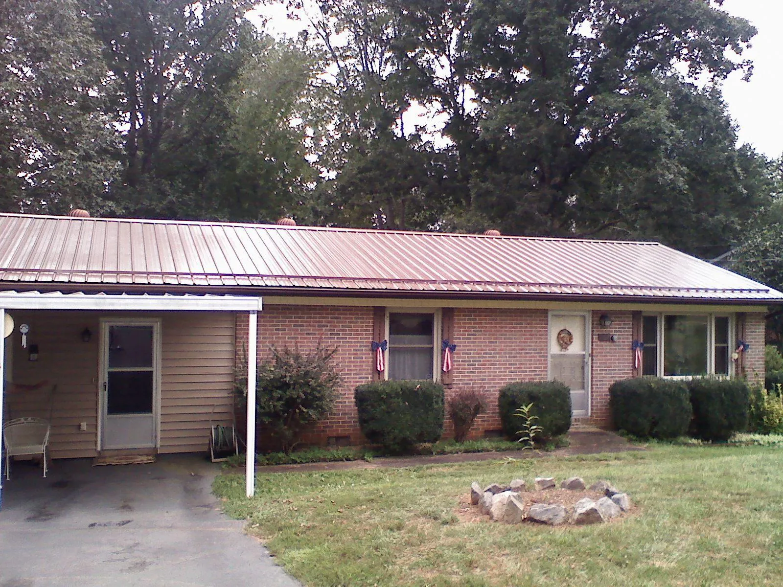Bronze metal roof and carport on a brick ranch home — Roof Repair work by our crew in West Jefferson